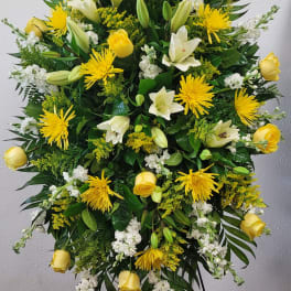 Large yellow and white floral standing spray on an easel