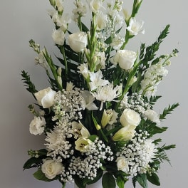 White floral arrangement in a white vase with tall blooms