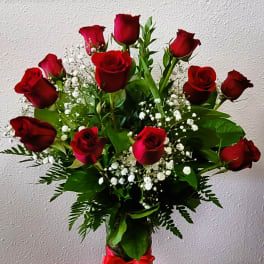 Bouquet of red roses with baby's breath in a glass vase