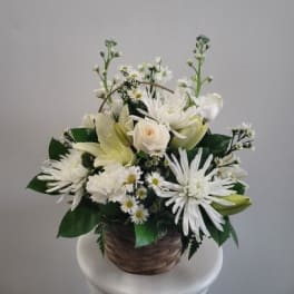 White floral arrangement in a woven basket