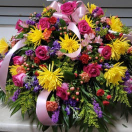 Large mixed bouquet of pink roses, yellow mums, and purple flowers with pink ribbon