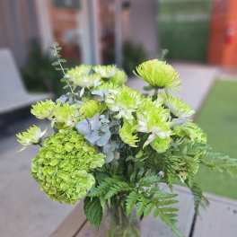 Green chrysanthemum and hydrangea bouquet in a glass vase