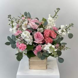 Pink and white floral arrangement in a wooden box