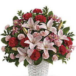 Pink lilies and red carnations in a woven glass vase