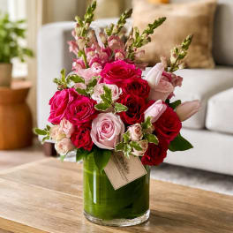 Pink and red roses with snapdragons in a glass vase