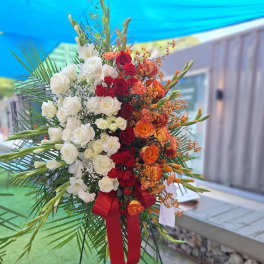 Large standing floral spray with white, red, and orange roses