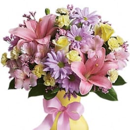 Pink and lavender mixed bouquet in a yellow vase with a pink ribbon