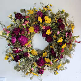 Circular wreath of dried purple, pink, and yellow flowers