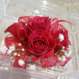 Red rose arrangement with white baby's breath in a clear box