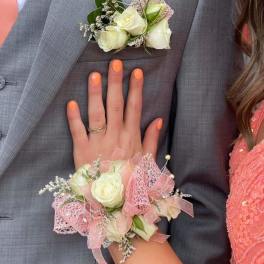 White rose boutonniere and wrist corsage with pink ribbon