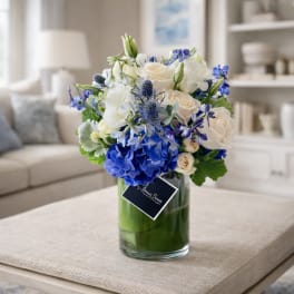 Blue and white flower arrangement in a glass vase