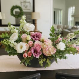 Low floral centerpiece with pink and white blooms in a black bowl vase