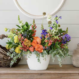 Colorful mixed flower arrangement in a white vase