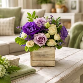 Purple and lavender roses arranged in a wooden box