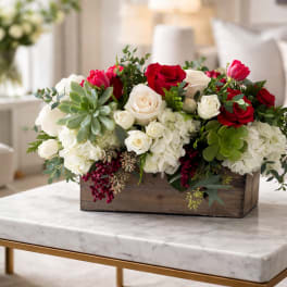 Arrangement of red and white roses in a wooden box
