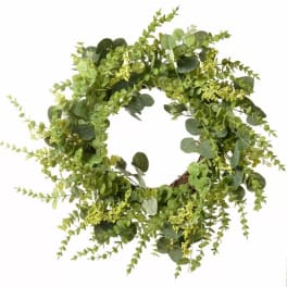 Circular wreath of mixed green foliage on a white background