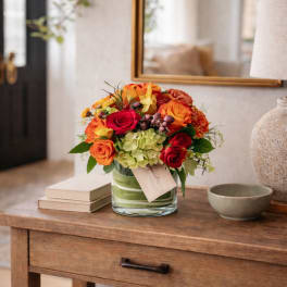 Bouquet of orange and red roses in a glass vase