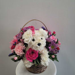 Basket arrangement with a teddy bear made of white carnations and pink flowers
