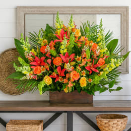 Bright mixed bouquet with orange and red flowers in a wooden box