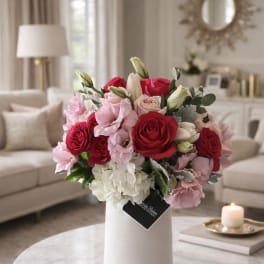 Bouquet of red, pink, and white flowers in a white vase