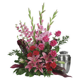 Pink lilies and roses arranged with a silver urn