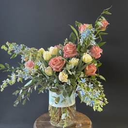 Mixed bouquet of pink roses and pale tulips in a glass vase