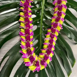 Two orchid leis on large tropical leaves