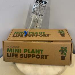 Plant care kit with a clear water pouch and cardboard box
