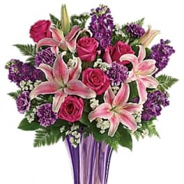 Pink lilies and roses in a purple vase