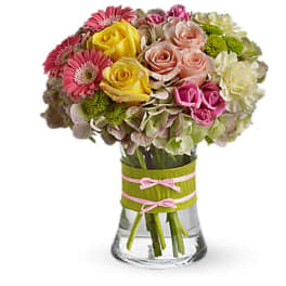 Mixed bouquet of roses, gerbera daisies, and hydrangeas in a glass vase