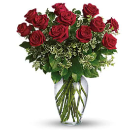 Red roses arranged in a clear glass vase