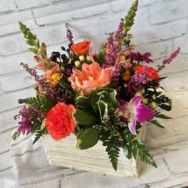 Mixed bouquet in a white wooden box with pink, orange, and purple flowers