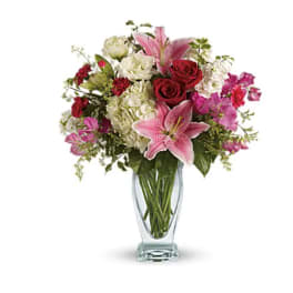 Pink lilies and red roses in a clear glass vase