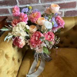 Bouquet of pink, peach, and white flowers tied with a gray ribbon