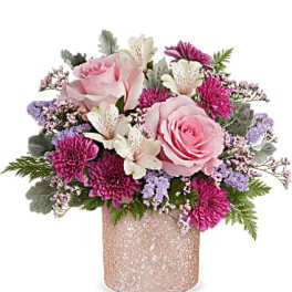 Pink roses and magenta blooms arranged in a glittery vase
