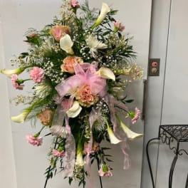 Tall floral standing spray with pink and white blooms and a pink ribbon