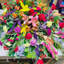 Large colorful floral arrangement with roses, lilies, and mixed blooms