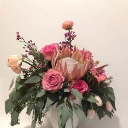 Pink and peach floral arrangement in a white vase