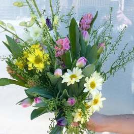 Mixed bouquet with yellow daisies, pink tulips, and white blooms