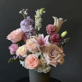 Pastel bouquet of roses, lilies, and mixed blooms in a vase