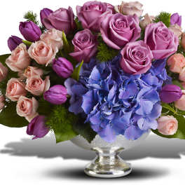 Lavender and pink roses with blue hydrangea in a silver vase