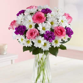 Pink roses and white daisies in a clear glass vase