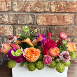 Colorful mixed flower arrangement in a white rectangular box