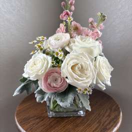 Pink and white rose bouquet in a square glass vase