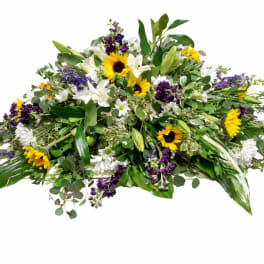 Large mixed floral spray with sunflowers, white lilies, and purple blooms