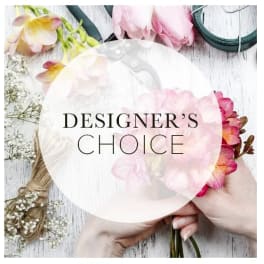 Hands holding a pink and peach floral bouquet with a "Designer’s Choice" label
