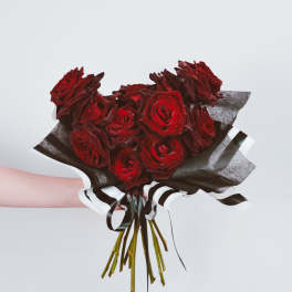 Bouquet of deep red roses wrapped in black and white paper