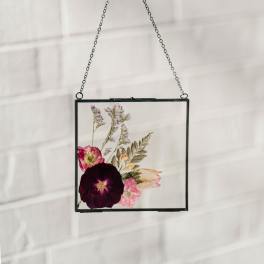 Pressed flowers in a black-framed hanging glass panel