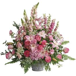 Pink lilies and roses arranged in a gray vase