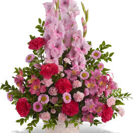 Pink gladiolus and mixed flowers in a woven basket